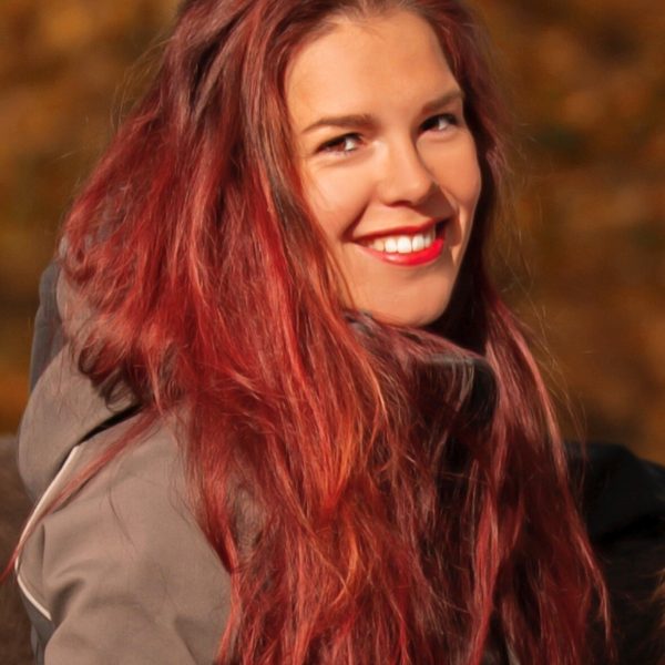 Sara van Doesburg met rood haar in herfstbos.